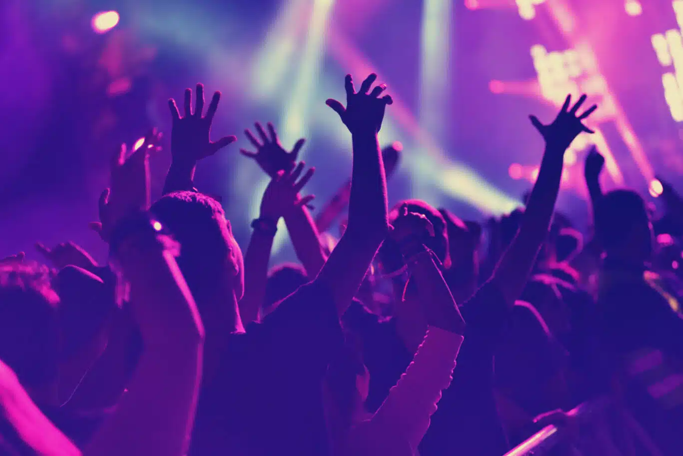 Rear,View,Of,Crowd,With,Arms,Outstretched,At,Concert